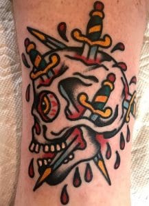 Tatuaje tradicional de calavera y daga