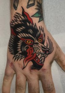 Tatuaje tradicional de mano de lobo