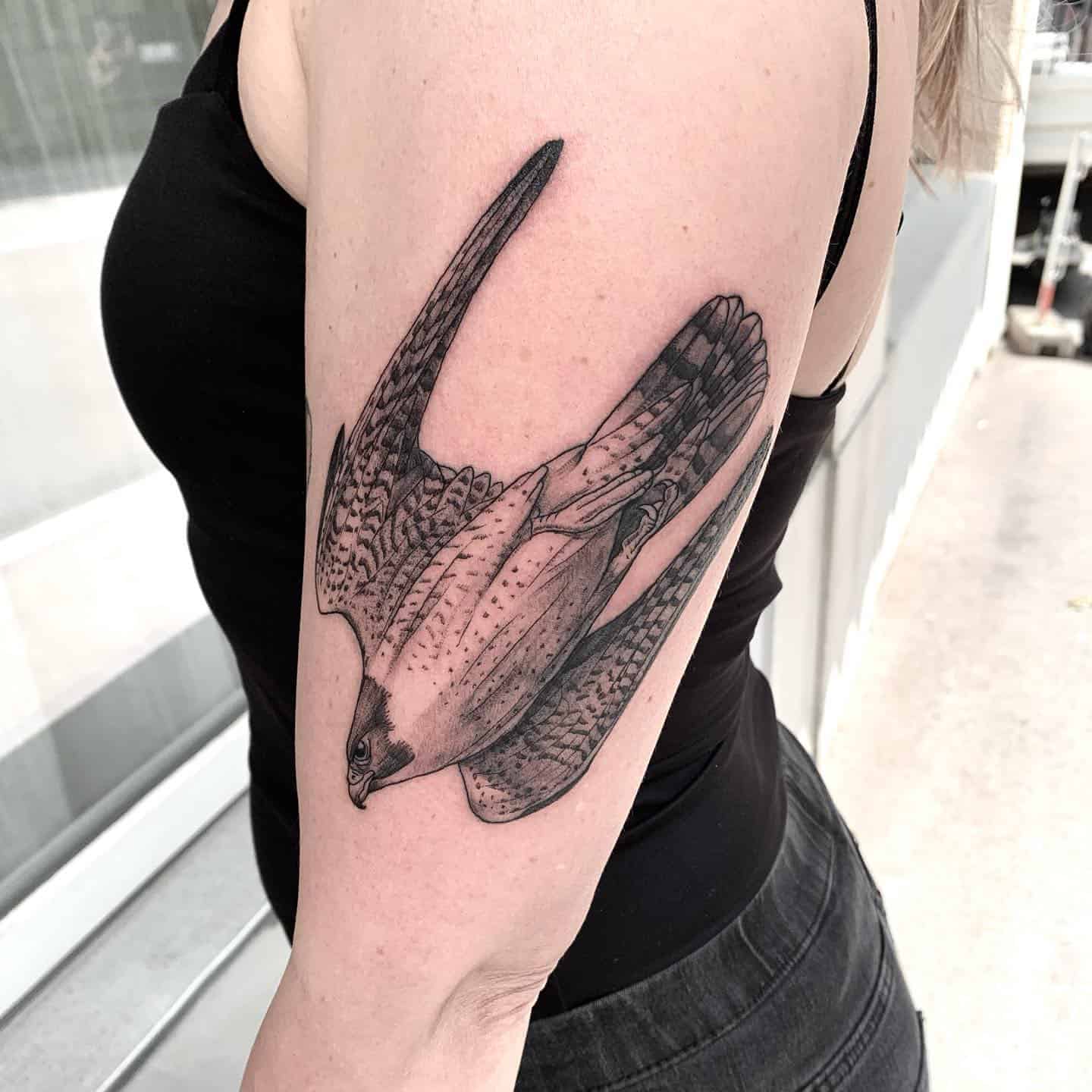 Tatuaje simbólico de un pájaro en el brazo