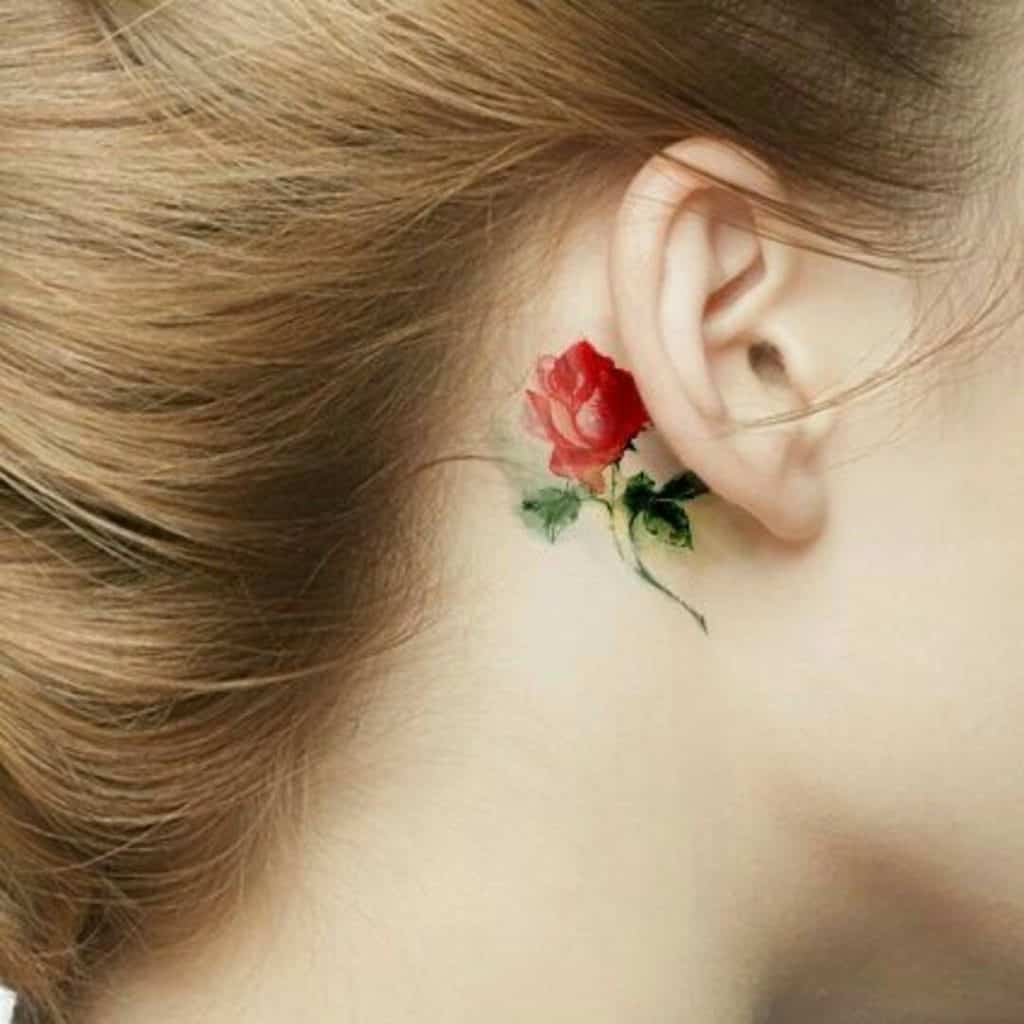 Tatuaje de una rosa roja detrás de la oreja