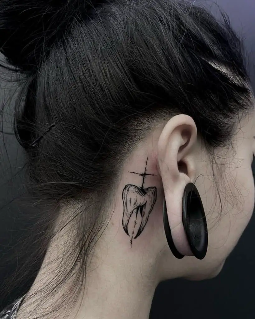 Divertido tatuaje detrás de la oreja inspirado en los dientes 