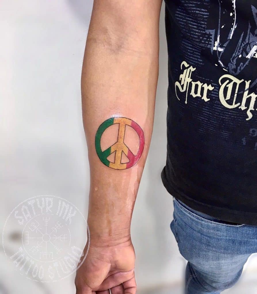 Tatuaje brillante en el antebrazo inspirado en la paz 