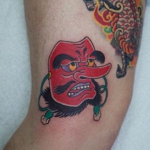 Tatuaje de máscara de tengu en el brazo