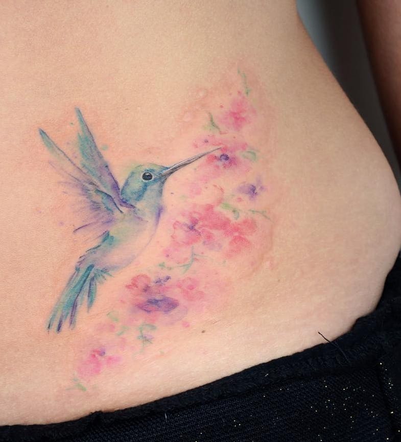 Tatuaje de colibrí y flor en acuarela
