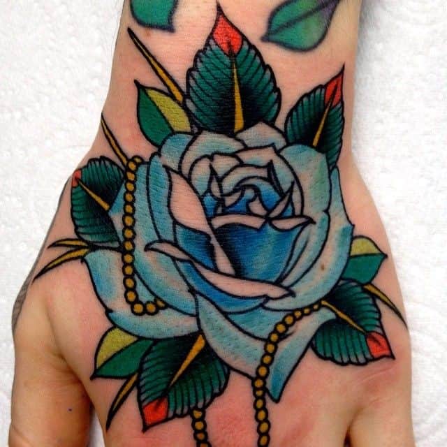 Tatuaje de una rosa azul en la mano