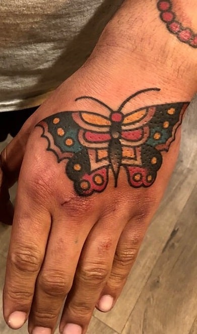 Tatuaje de mariposa tradicional en el dorso de la mano