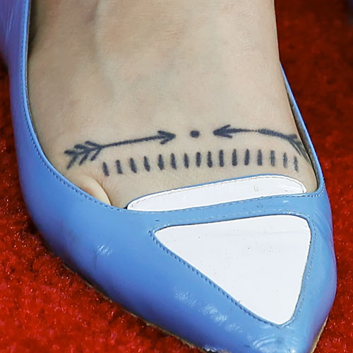 Tatuaje con flechas en las piernas de Zosia Mamet